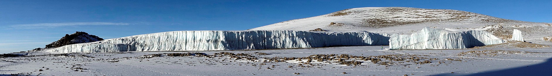 Der Furtwängler Gletscher in der Kibo-Kaldera mit Blick auf den Kegel des Reusch-Kraters im Jahr 2013. Als Größenvergleich zu beachten: Die Menschen
