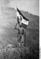 1906 Askari mit Flagge Deutsch-Ostafrika.jpg